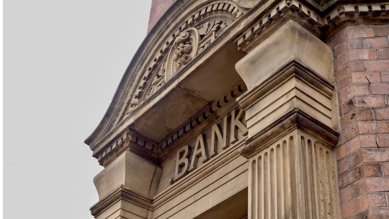 BANKと書かれたレンガ調の銀行の正面玄関